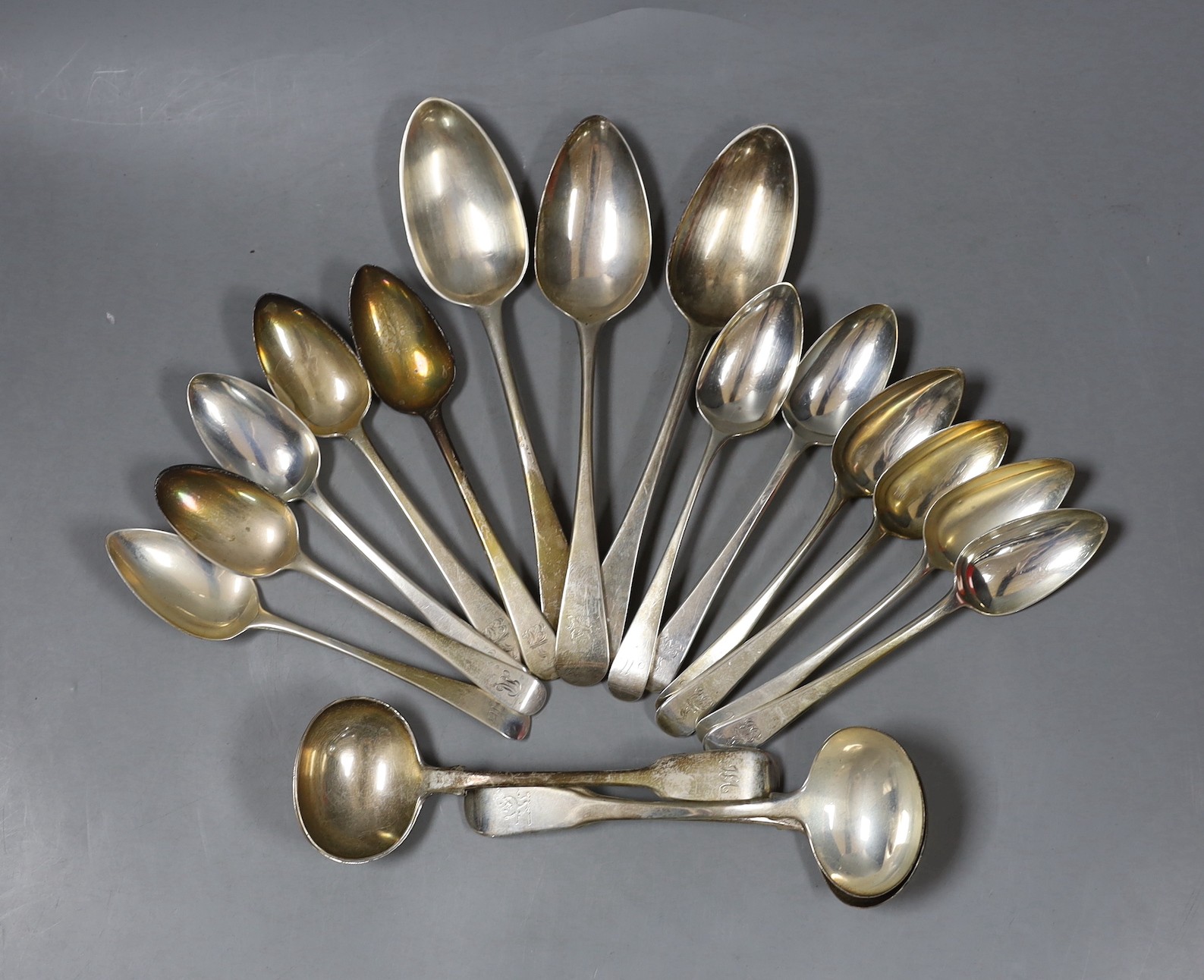 Fourteen assorted Georgian silver Old English pattern spoons and four sauce ladles, 27oz.